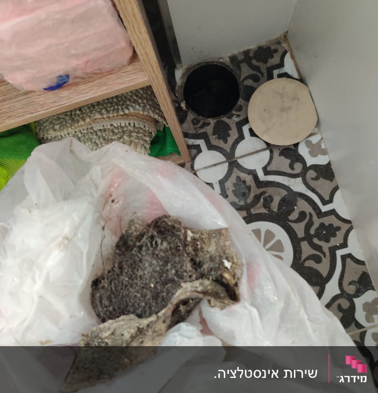 פתח ניקוז פתוח עם מכסה מונח בצד